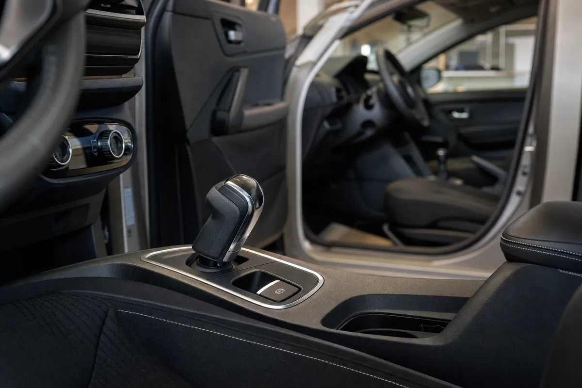 Consolle centrale di un’auto con selettore automatico e pulsante del freno di stazionamento elettronico